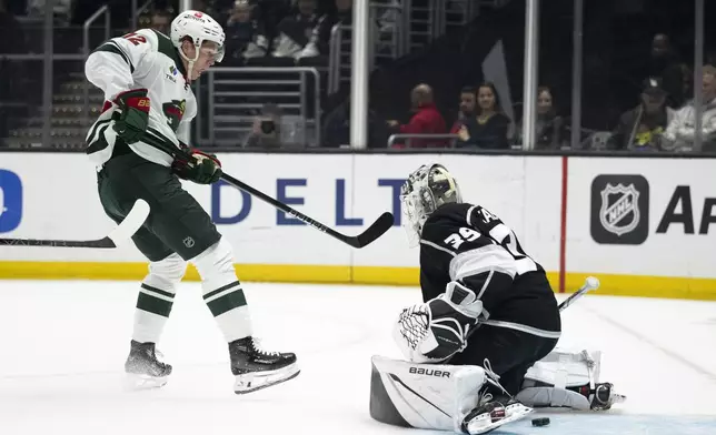 Minnesota Wild left wing Matt Boldy (12) scores past Los Angeles Kings goaltender Cam Talbot (39) during the first period of an NHL hockey game, Monday, April 15, 2024, in Los Angeles. (AP Photo/Kyusung Gong)