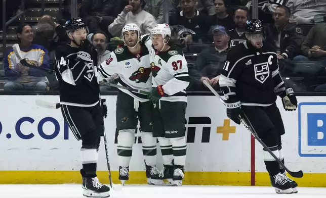 Minnesota Wild right wing Ryan Hartman (38) and left wing Kirill Kaprizov (97) celebrate after Hartman's goal during the second period of an NHL hockey game against the Los Angeles Kings, Monday, April 15, 2024, in Los Angeles. (AP Photo/Kyusung Gong)