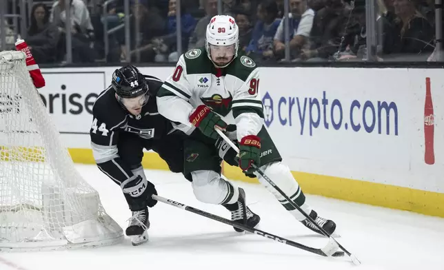 Minnesota Wild center Marcus Johansson (90) controls the puck as Los Angeles Kings defenseman Mikey Anderson (44) pursues him during the first period of an NHL hockey game, Monday, April 15, 2024, in Los Angeles. (AP Photo/Kyusung Gong)