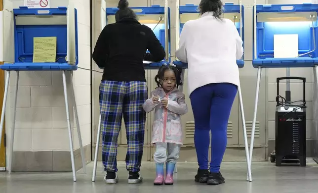 Three-year old- K-Lee waits as her mother Heather Ramsey votes during the Spring election Tuesday, April 2, 2024, in Milwaukee. (AP Photo/Morry Gash)