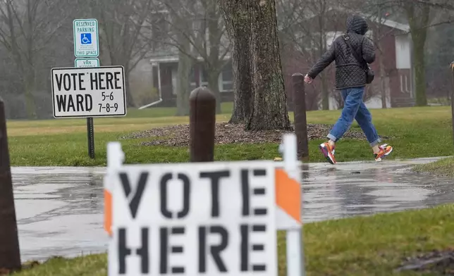 A voter braves a cold rain running to cast a ballot during the Spring election Tuesday, April 2, 2024, in Fox Point, Wis. (AP Photo/Morry Gash)