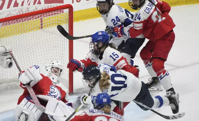 Czechia goaltender Klara Peslarova (29) makes a save against Finland's Elisa Holopainen (10) during first-period bronze medal hockey game action at the women's world hockey championships in Utica, N.Y., Sunday, April 14, 2024. (Christinne Muschi/The Canadian Press via AP)
