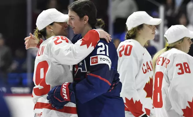 United States forward Hilary Knight, right, hugs Canada forward Marie-Philip Poulin after Canada won the final at the IIHF Women's World Hockey Championships in Utica, N.Y., Sunday, April 14, 2024. (AP Photo/Adrian Kraus)