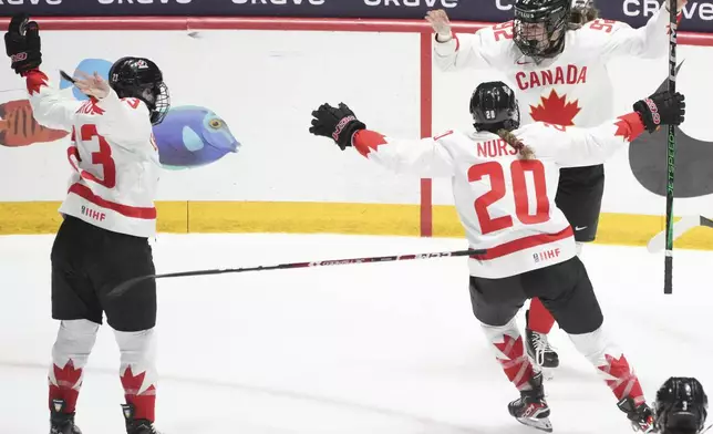 Canada's Danielle Serdachny celebrates her goal over the United States with teammates Erin Ambrose and Sarah Nurse (20) during overtime in their gold medal game at the women's world hockey championships in Utica, N.Y., Sunday, April 14, 2024. (Christinne Muschi/The Canadian Press via AP)