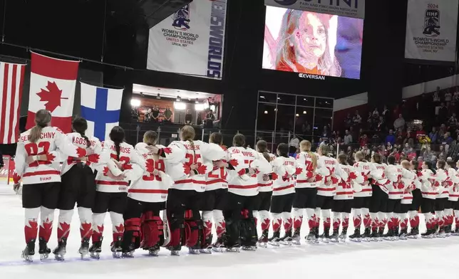 Canada players watch as they raise the flags following their gold medal win over United States at the women's world hockey championships in Utica, N.Y., Sunday, April 14, 2024. (Christinne Muschi/The Canadian Press via AP)