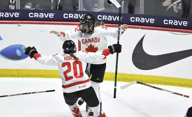 Canada forward Danielle Serdachny, right, celebrates with forward Sarah Nurse after scoring the winning goal against the United States during overtime in the final at the women's world hockey championships in Utica, N.Y., Sunday, April 14, 2024. (AP Photo/Adrian Kraus)