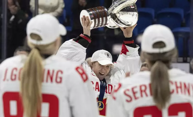 Canada goaltender Ann-Renee Desbiens (35) hoists the trophy following their gold medal win over United States at the women's world hockey championships in Utica, N.Y., Sunday, April 14, 2024. (Christinne Muschi/The Canadian Press via AP)
