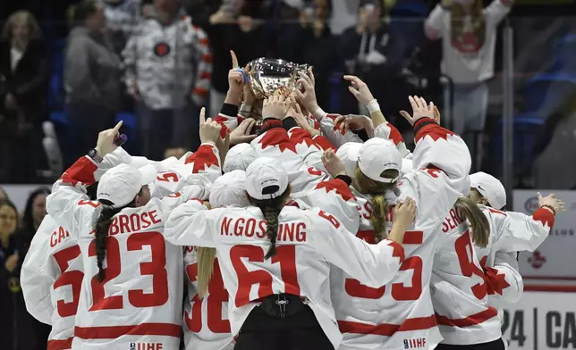 Team Canada raises the championship cup after beating the United States in the final at the women's world hockey championships in Utica, N.Y., Sunday, April 14, 2024. (AP Photo/Adrian Kraus)