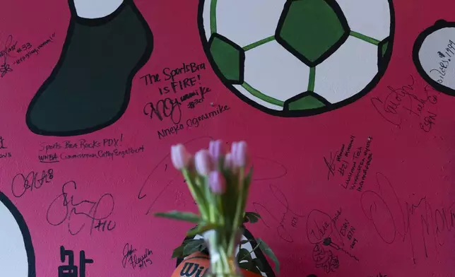 Autographs from WNBA commissioner Cathy Engelbert and professional basketball player Nneka Ogwumike are seen on the wall at The Sports Bra sports bar on Wednesday, April 24, 2024, in Portland, Ore. Ogwumike now plays for the Seattle Storm. (AP Photo/Jenny Kane)
