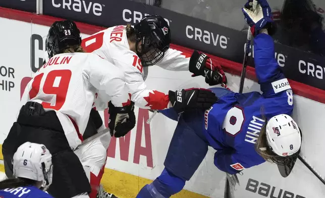 United States' Haley Winn (8) is upended behind the net by Canada's Brianne Jenner (19) during the first period of a hockey game at the IIHF Women's World Hockey Championship in Utica, N.Y., Monday, April 8, 2024. (Christinne Muschi/The Canadian Press via AP)