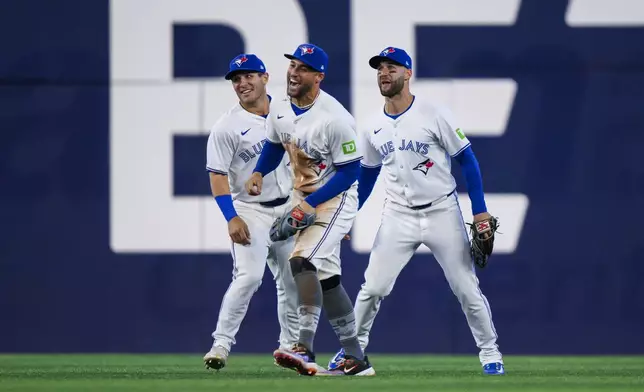 Toronto Blue Jays teammates Daulton Varsho, Kevin Kiermaier and George Springer celebrate after defeating the New York Yankees in a baseball game in Toronto on Monday, April 15, 2024. (Christopher Katsarov/The Canadian Press via AP)