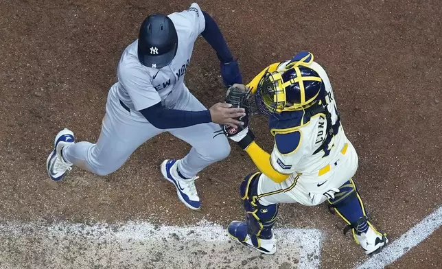 Milwaukee Brewers catcher William Contreras tags out New York Yankees' Jahmai Jones at home during the 11th inning of a baseball game Friday, April 26, 2024, in Milwaukee. (AP Photo/Morry Gash)