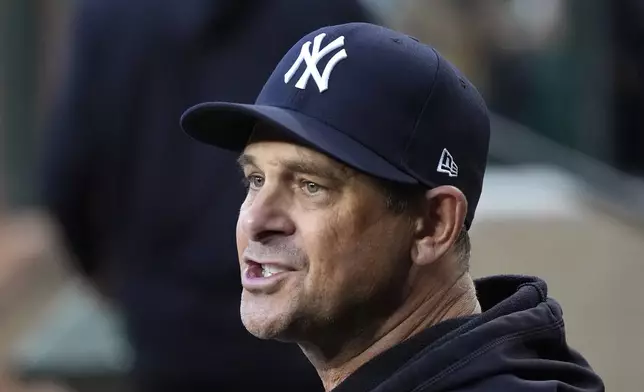 New York Yankees manager Aaron Boone talks with a player in the dugout during the first inning of a baseball game against the Arizona Diamondbacks Tuesday, April 2, 2024, in Phoenix. (AP Photo/Ross D. Franklin)