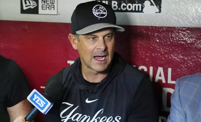 New York Yankees manager Aaron Boone speaks to reporters in the dugout prior to the team's baseball game against the Arizona Diamondbacks on Tuesday, April 2, 2024, in Phoenix. (AP Photo/Ross D. Franklin)
