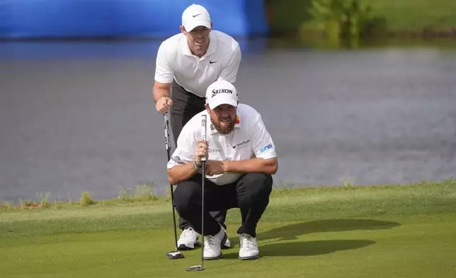 Rory McIlroy, of Northern Ireland, standing, and his teammate Shane Lowry, of Ireland, line up a shot on the 17th green during the final round of the PGA Zurich Classic golf tournament at TPC Louisiana in Avondale, La., Sunday, April 28, 2024. (AP Photo/Gerald Herbert)