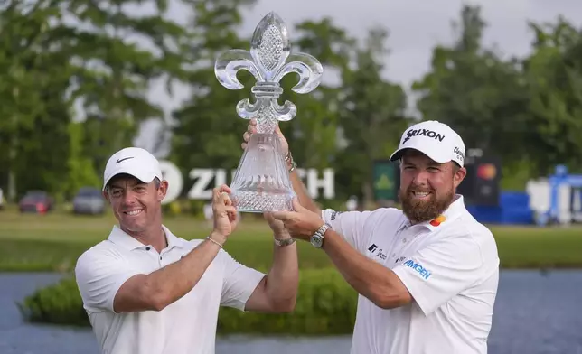 Rory McIlroy, of Northern Ireland, and teammate Shane Lowry, of Ireland, right hold up their trophy after winning the PGA Zurich Classic golf tournament at TPC Louisiana in Avondale, La., Sunday, April 28, 2024. (AP Photo/Gerald Herbert)