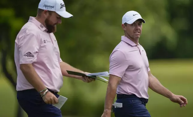 Rory McIlroy, right, of Northern Ireland, and teammate Shane Lowry, of Ireland, walk down the first fairway during the first round of the PGA Zurich Classic golf tournament at TPC Louisiana in Avondale, La., Thursday, April 25, 2024. (AP Photo/Gerald Herbert)