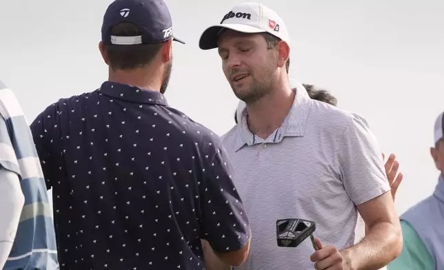Chad Ramey, left, shakes hands with teammate Martin Trainer after being eliminated in a playoff against Rory McIlroy, of Northern Ireland, and Shane Lowry, of Ireland, finishing second in the PGA Zurich Classic golf tournament at TPC Louisiana in Avondale, La., Sunday, April 28, 2024. (AP Photo/Gerald Herbert)