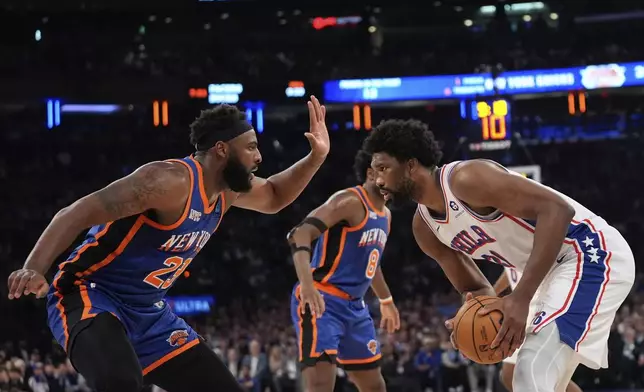 New York Knicks' Mitchell Robinson, left, defends Philadelphia 76ers' Joel Embiid, right, during the first half of Game 5 in an NBA basketball first-round playoff series, Tuesday, April 30, 2024, in New York. (AP Photo/Frank Franklin II)