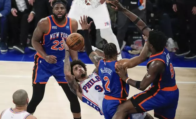 Philadelphia 76ers' Kelly Oubre Jr. (9) shoots over New York Knicks' Miles McBride (2), Mitchell Robinson (23) and OG Anunoby (8) during the second half of Game 5 in an NBA basketball first-round playoff series, Tuesday, April 30, 2024, in New York. The 76ers won 112-106 in overtime. (AP Photo/Frank Franklin II)
