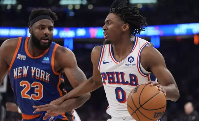 Philadelphia 76ers' Tyrese Maxey (0) looks to pass as New York Knicks' Mitchell Robinson (23) defends during the first half of Game 5 in an NBA basketball first-round playoff series, Tuesday, April 30, 2024, in New York. (AP Photo/Frank Franklin II)