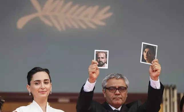 ADDING IDs OF PEOPLE IN PHOTOGRAPHS Director Mohammad Rasoulof holds up photographs of actors Soheila Golestani, right, and Missagh Zareh alongside Soheila Golestani, left, upon arrival at the premiere of the film 'The Seed of the Sacred Fig' at the 77th international film festival, Cannes, southern France, Friday, May 24, 2024. (Photo by Scott A Garfitt/Invision/AP)