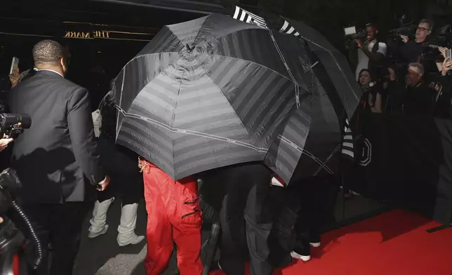 Umbrellas cover a person as they depart The Mark Hotel prior to attending The Metropolitan Museum of Art's Costume Institute benefit gala celebrating the opening of "Sleeping Beauties: Reawakening Fashion" on Monday, May 6, 2024, in New York. (Photo by CJ Rivera/Invision/AP)