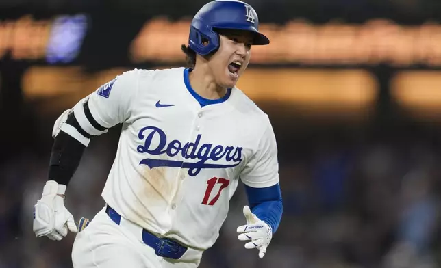 Los Angeles Dodgers designated hitter Shohei Ohtani reacts after a single during the tenth inning of a baseball game against the Atlanta Braves in Los Angeles, Friday, May 3, 2024. Chris Taylor scored. (AP Photo/Ashley Landis)