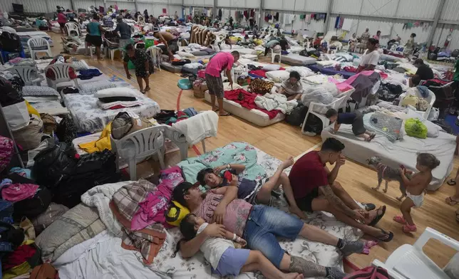 Residents rest in a makeshift shelter for people whose homes were flooded by heavy rains, in Canoas, Rio Grande do Sul state, Brazil, Wednesday, May 8, 2024. (AP Photo/Carlos Macedo)