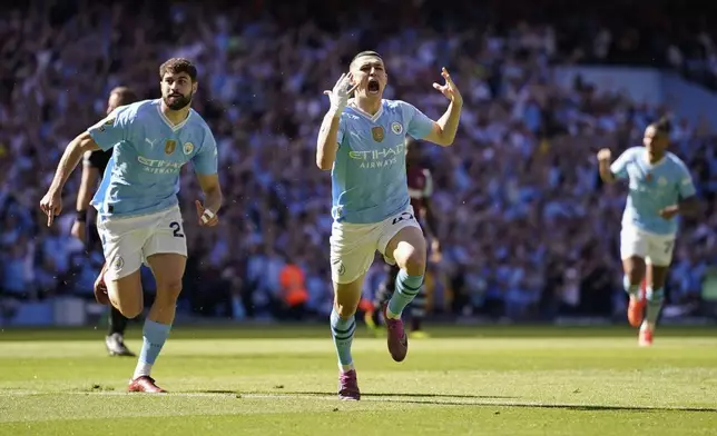 Manchester City's Phil Foden, center, celebrates after scoring his side's opening goal during the English Premier League soccer match between Manchester City and West Ham United at the Etihad Stadium in Manchester, England, Sunday, May 19, 2024. (AP Photo/Dave Thompson)