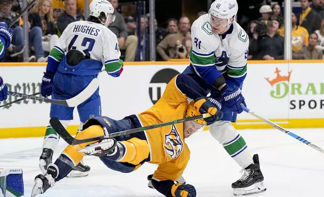 Vancouver Canucks defenseman Nikita Zadorov (91) pulls Nashville Predators center Mark Jankowski, left, down to the ice during the second period in Game 6 of an NHL hockey Stanley Cup first-round playoff series Friday, May 3, 2024, in Nashville, Tenn. (AP Photo/George Walker IV)
