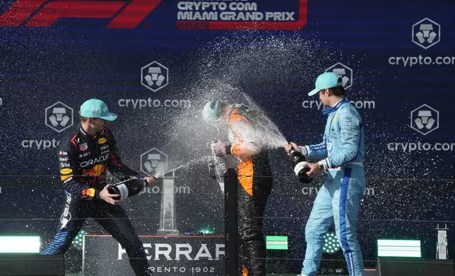 Second place winner, Red Bull driver Max Verstappen, of the Netherlands, left, and third place winner Ferrari driver Charles Leclerc, of Monaco, right, spray champagne on winner, McLaren driver Lando Norris, of Britain, after the Formula One Miami Grand Prix auto race at the Miami International Autodrome, Sunday, May 5, 2024, in Miami Gardens, Fla. (AP Photo/Wilfredo Lee)