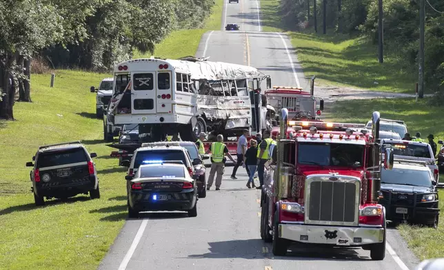 Authorities work at the scene of a deadly crash after a bus carrying farmworkers collided with a pickup truck on State Road 40 Tuesday, May 14, 2024, near Dunnellon, Fla. The driver of the pick up, Bryan Maclean Howard, was charged with eight counts of DUI manslaughter. (AP Photo/Alan Youngblood)