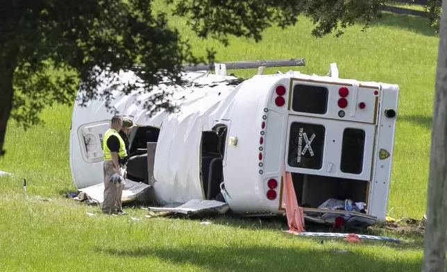 Authorities work at the scene of a deadly crash after a bus carrying farmworkers collided with a pickup truck on State Road 40 Tuesday, May 14, 2024, near Dunnellon, Fla. (AP Photo/Alan Youngblood)