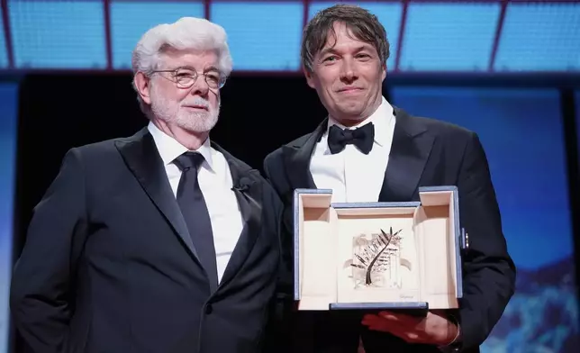 Sean Baker, right, holds the Palme d'Or for the film 'Anora,' alongside George Lucas during the awards ceremony of the 77th international film festival, Cannes, southern France, Saturday, May 25, 2024 (Photo by Andreea Alexandru/Invision/AP)