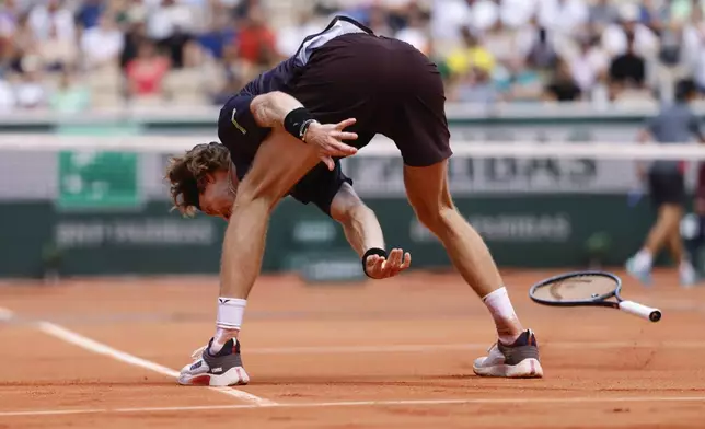 Russia's Andrey Rublev throws his racket on the clay court in frustration during his first round match of the French Open tennis tournament against Japan's Taro Daniel at the Roland Garros stadium in Paris, Sunday, May 26, 2024. (AP Photo/Jean-Francois Badias)
