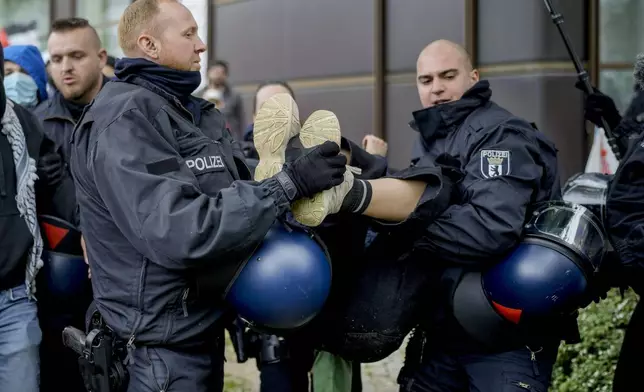 A person is carried away by police officers during a pro-Palestinians demonstration by the group "Student Coalition Berlin" in the theater courtyard of the 'Freie Universität Berlin' university in Berlin, Germany, Tuesday, May 7, 2024. Pro-Palestinian activists occupied a courtyard of the Free University in Berlin on Tuesday. (AP Photo/Markus Schreiber)