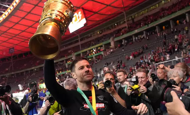Leverkusen's head coach Xabi Alonso lifts the trophy after the German Soccer Cup final match between 1. FC Kaiserslautern and Bayer Leverkusen at the Olympic Stadium in Berlin, Germany, Saturday, May 25, 2024. (AP Photo/Matthias Schrader)
