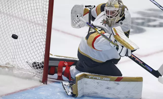 Vegas Golden Knights goaltender Adin Hill eyes the puck on a scoring shot by Dallas Stars center Radek Faksa during the third period in Game 7 of an NHL hockey Stanley Cup first-round playoff series, Sunday, May 5, 2024, in Dallas. (AP Photo/Brandon Wade)