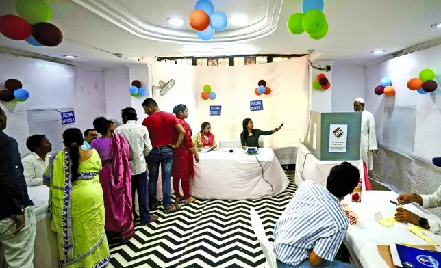 Voters queue up inside a polling booth to cast their vote in the sixth round of polling in India's national election in New Delhi, India, Saturday, May 25, 2024. (AP Photo/Manish Swarup)