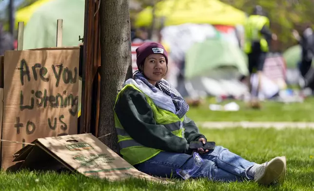 A woman sits outside an encampment area on the University of Wisconsin-Milwaukee campus, Tuesday, April 30, 2024, in Milwaukee. The Pro-Palestinian rally is calling for the University to cut ties with Israel and for peace in Gaza. (AP Photo/Morry Gash)