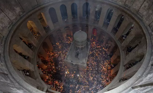 Christian pilgrims hold candles during the Holy Fire ceremony, a day before Easter, at the Church of the Holy Sepulcher, where many Christians believe Jesus was crucified, buried and resurrected, in Jerusalem's Old City, Saturday, May 4, 2024. (AP Photo/Ohad Zwigenberg)