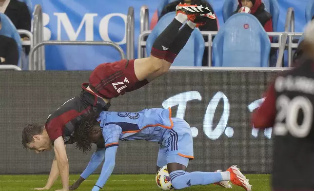 Toronto FC defender Sigurd Rosted (17) falls over New York City FC forward Malachi Jones (88) during the first half of an MLS soccer match Saturday, May 11, 2024, in Toronto. (Frank Gunn/The Canadian Press via AP)