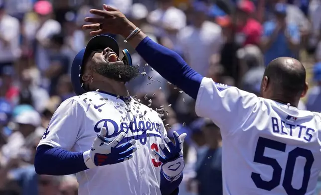 Los Angeles Dodgers' Teoscar Hernández, left, is hit with sunflower seeds thrown by Mookie Betts after hitting a two-run home run during the sixth inning of a baseball game against the Miami Marlins Wednesday, May 8, 2024, in Los Angeles. (AP Photo/Mark J. Terrill)