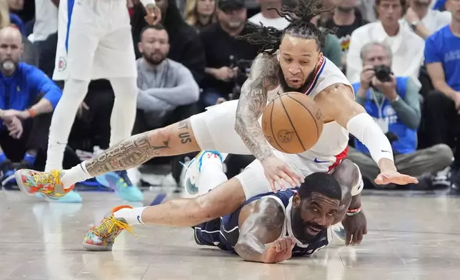 Los Angeles Clippers guard Amir Coffey, top, and Dallas Mavericks guard Kyrie Irving dive for a loose ball during the second half in Game 5 of an NBA basketball first-round playoff series Wednesday, May 1, 2024, in Los Angeles. (AP Photo/Mark J. Terrill)