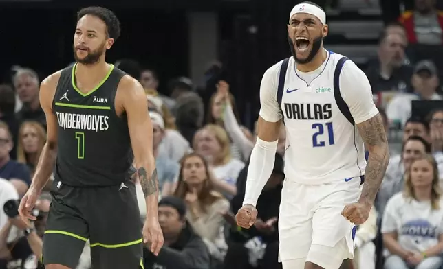 Dallas Mavericks center Daniel Gafford (21) celebrates a Minnesota Timberwolves shot clock violation as Minnesota Timberwolves forward Kyle Anderson (1) pauses on the court during the first half of Game 5 of the Western Conference finals in the NBA basketball playoffs, Thursday, May 30, 2024, in Minneapolis. (AP Photo/Abbie Parr)