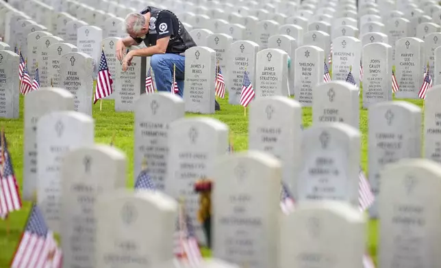 Bill Harvey kneels at the grave of his oldest son, U.S. Army Sgt. 1st Class Matthew Harvey, on Memorial Day at the Houston National Cemetery, Monday, May 27, 2024, in Houston. (Brett Coomer/Houston Chronicle via AP)