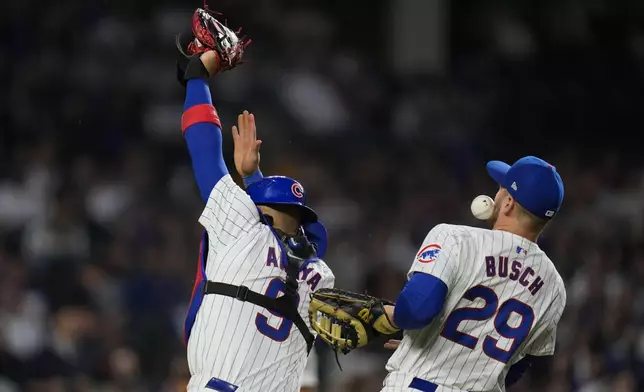 Chicago Cubs catcher Miguel Amaya, left, and first baseman Michael Busch collide and are unable to catch a ball hit by San Diego Padres' Manny Machado during the sixth inning of a baseball game Tuesday, May 7, 2024, in Chicago. (AP Photo/Erin Hooley)