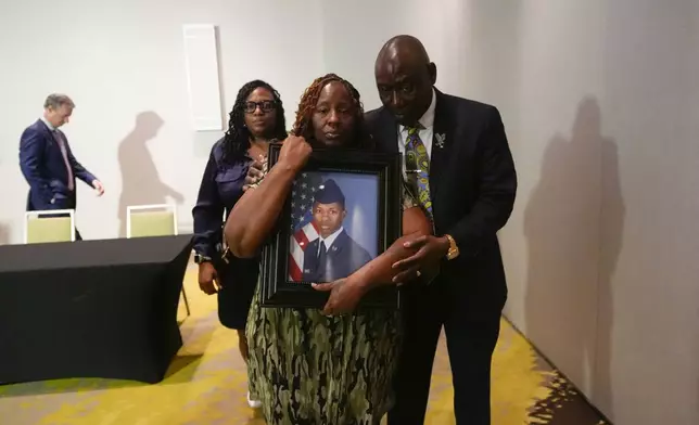 Attorney Ben Crump walks with Chantimekki Fortson, mother of Roger Fortson, a U.S. Navy airman, as they leave a news conference about his death, Thursday, May 9, 2024, in Fort Walton Beach, Fla. Fortson was shot and killed by police in his apartment on May 3, 2024. (AP Photo/Gerald Herbert)