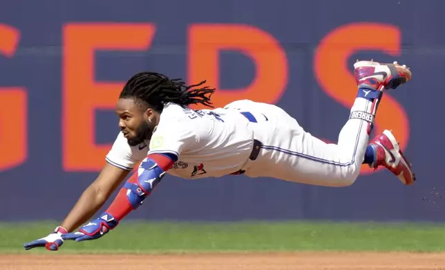 Toronto Blue Jays' Vladimir Guerrero Jr. (27) dives to slide safe into second base for a double during the fourth inning of a baseball game against the Tampa Bay Rays, Saturday, May 18, 2024, in Toronto. (Chris Young/The Canadian Press via AP)